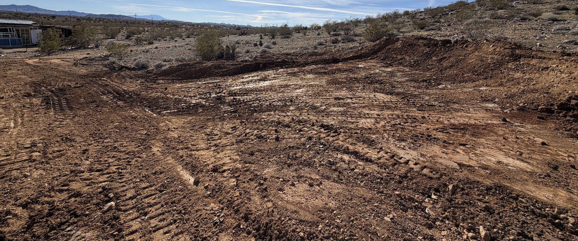 Cleared desert parcel with brush piles and a ridge line beyond