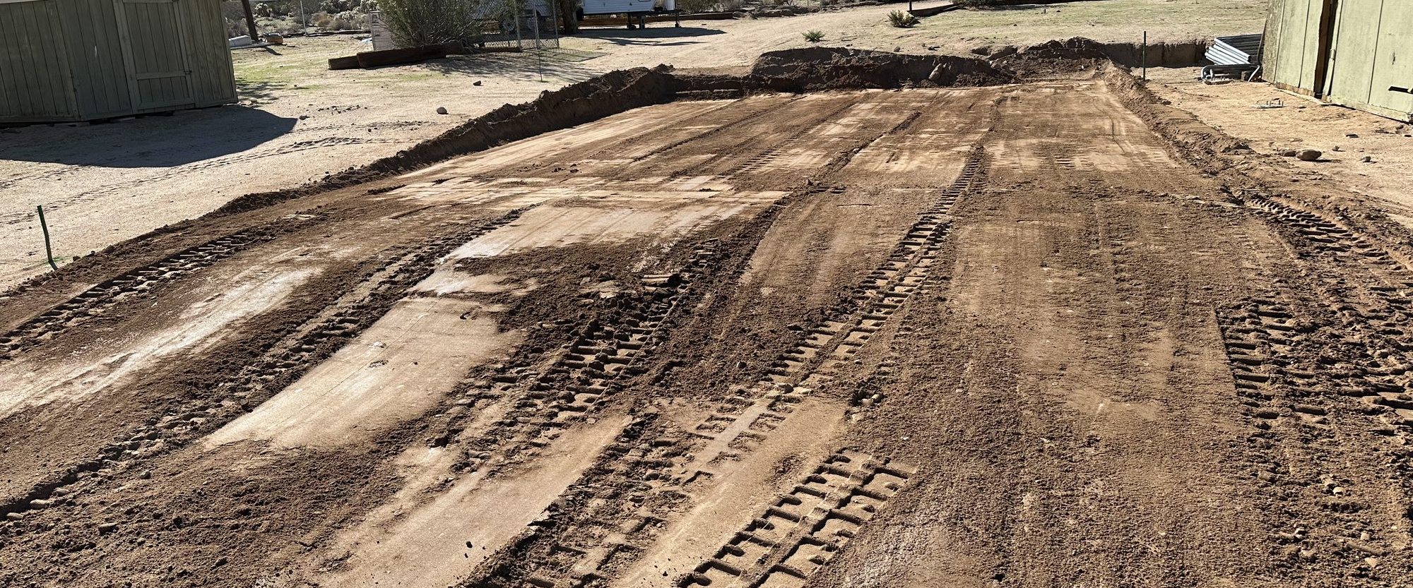 Freshly graded access road with track marks