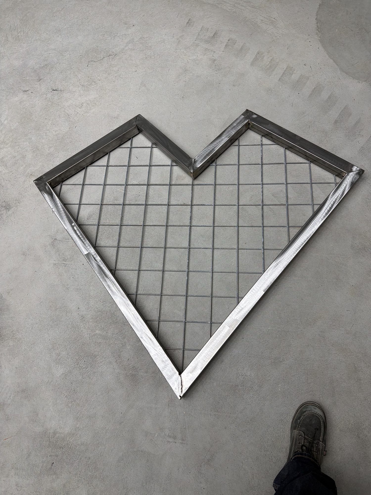 Heart-shaped steel trellis with wire mesh on the shop floor