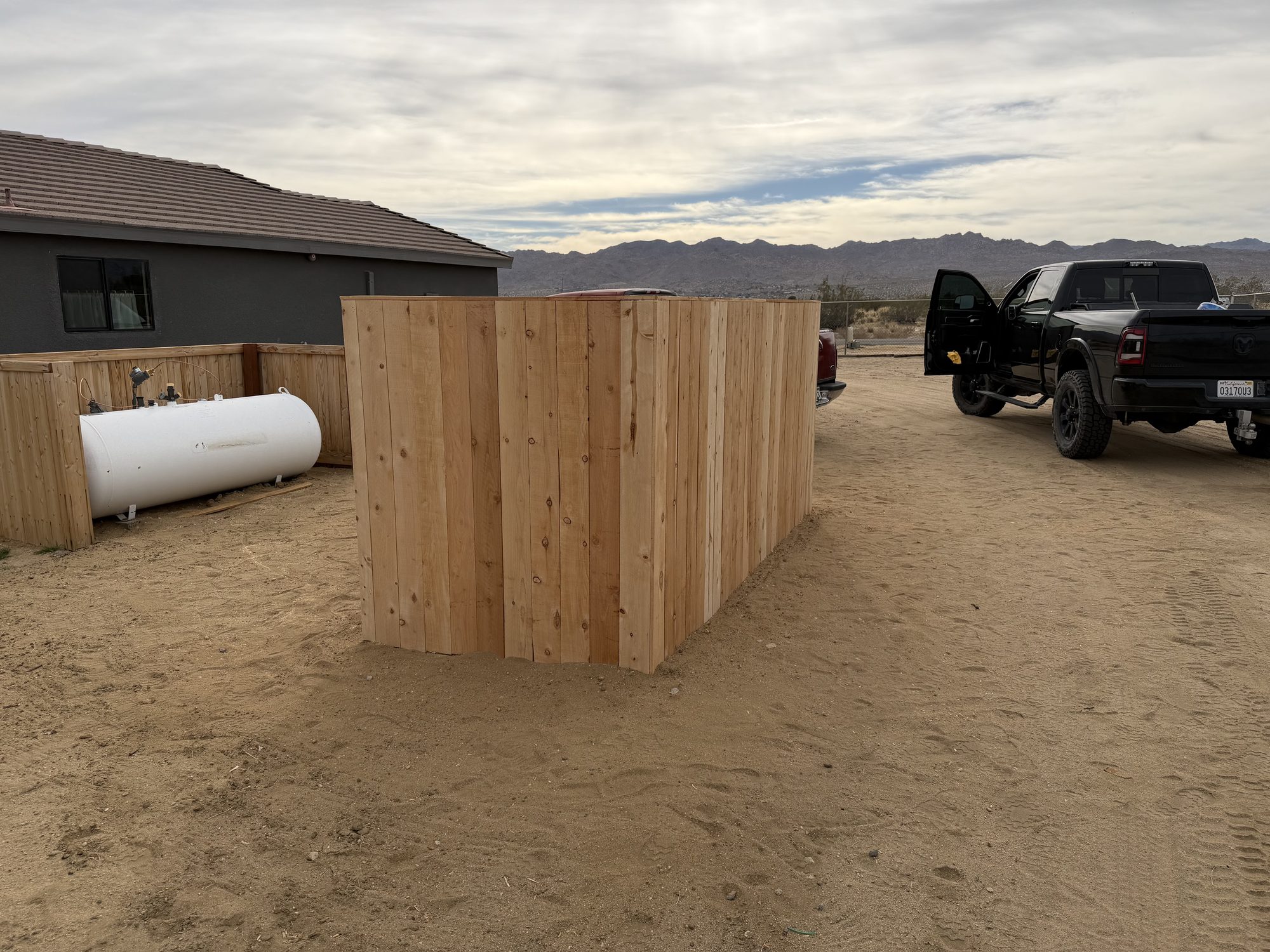 Cedar screen wall built around a propane tank with a work truck