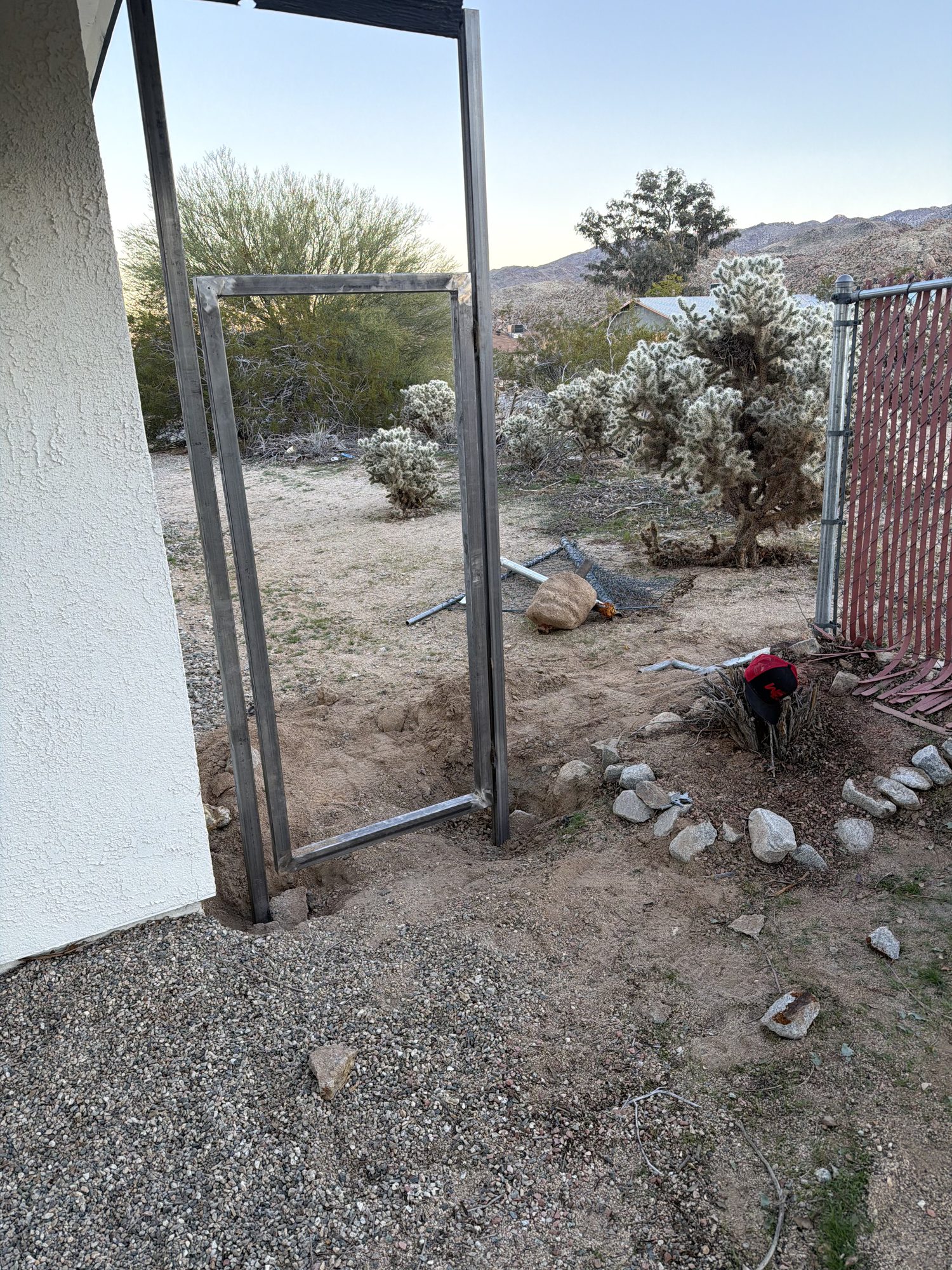 Steel gate frame posts set at a stucco house
